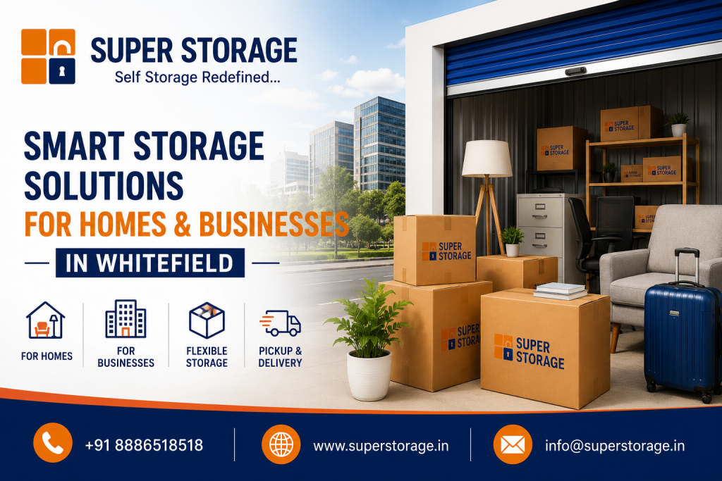 An informational marketing banner showing an open drive-up storage unit packed with office and home items, fronted by stacked branded cardboard boxes, a dark blue suitcase, and a potted plant, with a city street and high-rise office buildings in the background.