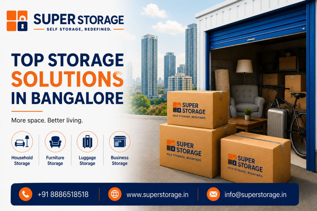 A promotional banner for Super Storage highlighting premium self-storage in Bangalore, featuring an open rooftop-style garage storage unit with a blue roll-up door overlooking a city skyline, filled with home furnishings including an armchair, floor lamp, coffee table, bicycle, silver suitcase, and stacked shelving boxes, alongside three stacked Super Storage cardboard boxes in the foreground, accompanied by the headline "Top Storage Solutions In Bangalore: More space. Better living.", service icons for "Household Storage", "Furniture Storage", "Luggage Storage", and "Business Storage", and Super Storage contact details at the bottom.